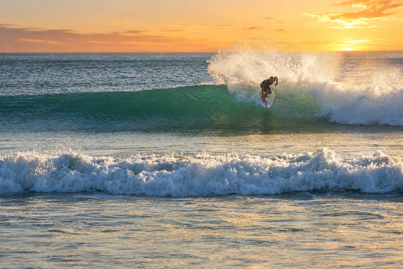 Surfer riding a wave at sunset off Playa Marbella