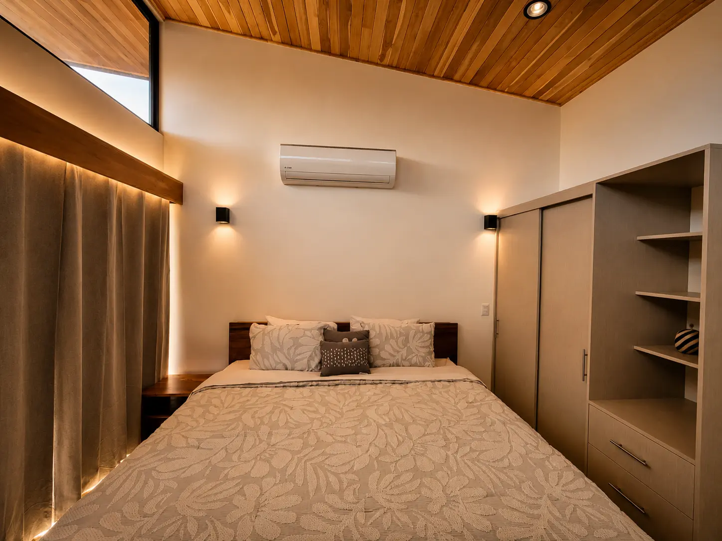 King bed with wood ceiling, built-in wardrobe and soft wall lighting