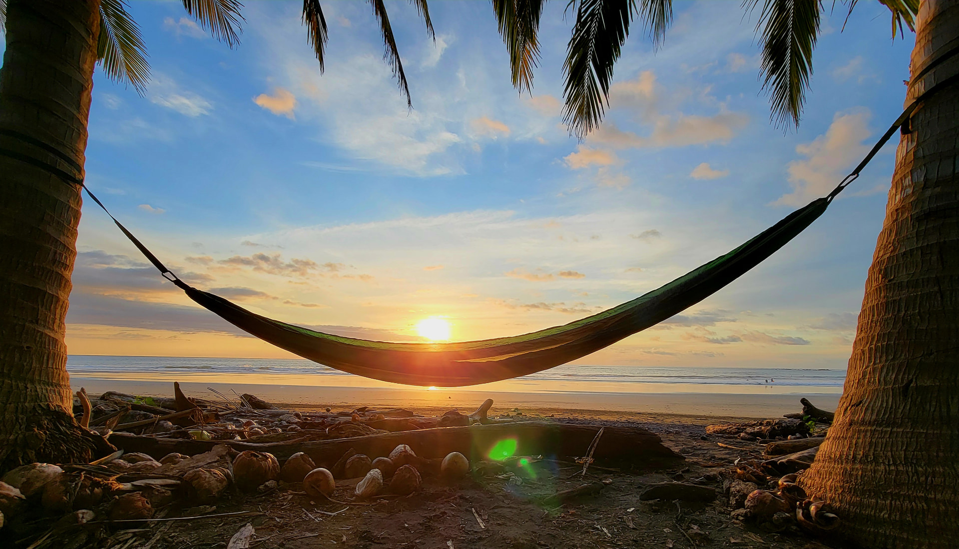 Hammock strung between palms at sunset on Playa Marbella